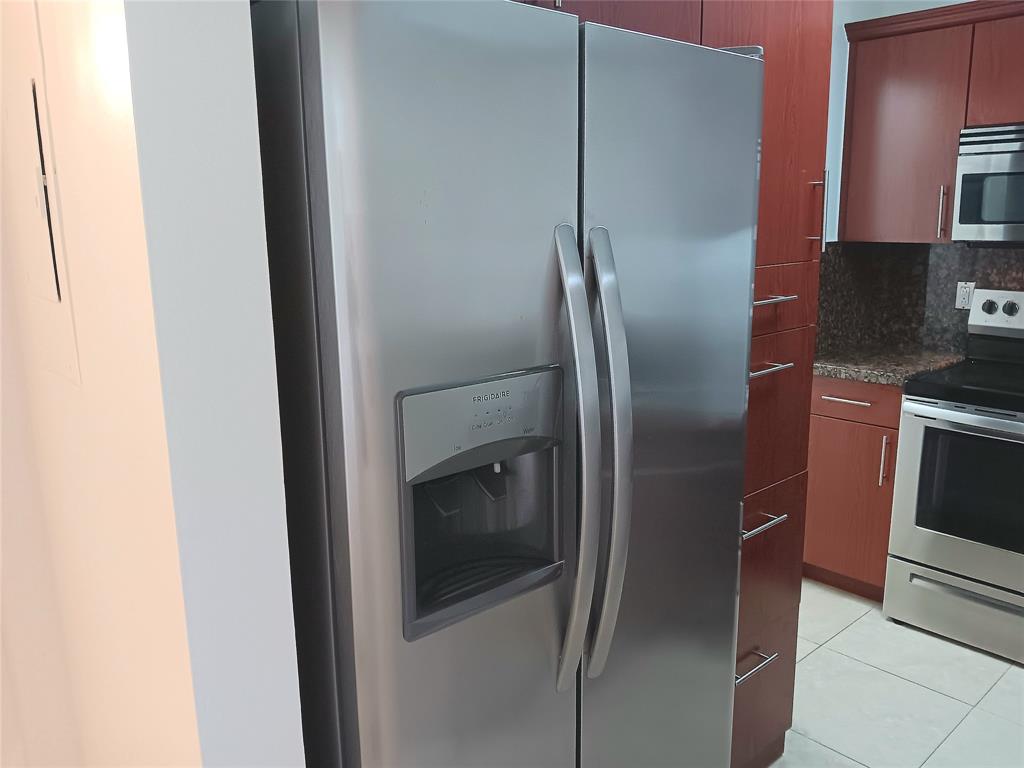 1265 Southwest 46th Avenue, Unit 2207 Pompano Beach, FL 33069 - Photo 6 of 33 a metallic refrigerator freezer sitting in a kitchen