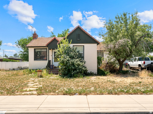 72 Cox Lane Midvale, UT 84047 - Photo 1 of 16 Charming property featuring a light-colored exterior with dark trim and a distinctive tiled roof