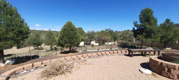 a view of a patio with table and chairs potted plants and large tree