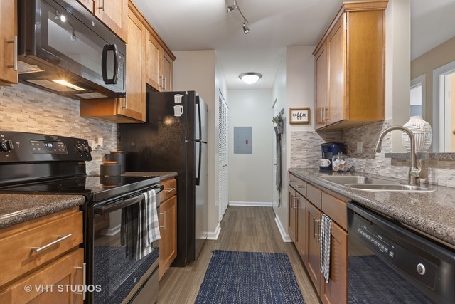 38 Sterling Circle, Unit 207 Wheaton, IL 60189 - Photo 13 of 14 a kitchen with stainless steel appliances granite countertop a sink stove and refrigerator