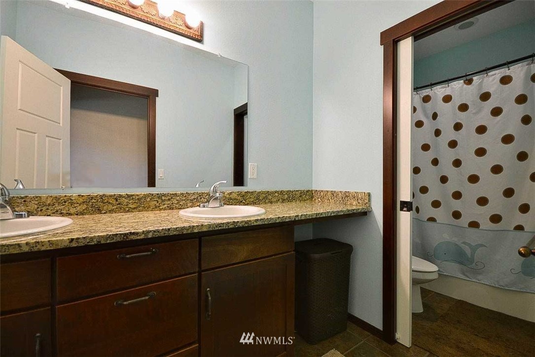 19930 Bear View Lane Southwest Rochester, WA 98579 - Photo 13 of 25 a bathroom with a granite countertop sink and a mirror