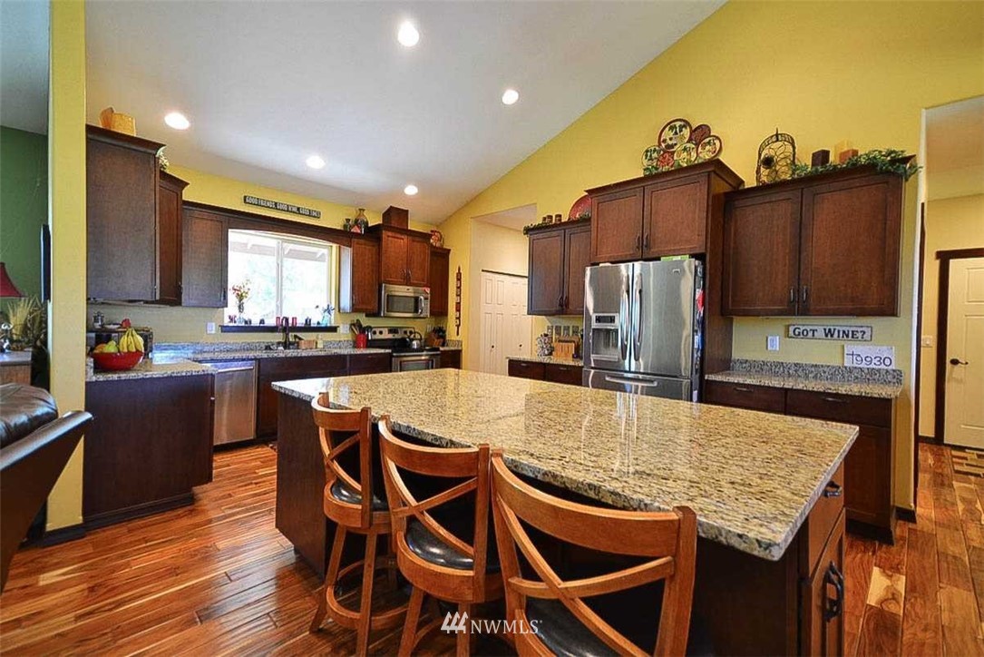 19930 Bear View Lane Southwest Rochester, WA 98579 - Photo 6 of 25 a kitchen with stainless steel appliances granite countertop a kitchen island a stove a table and chairs