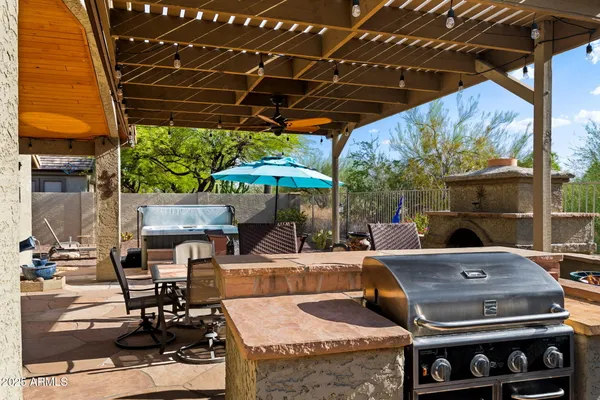 a view of a patio with table and chairs under an umbrella