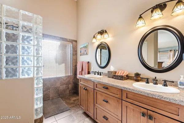 a bathroom with a granite countertop double vanity sink and a mirror