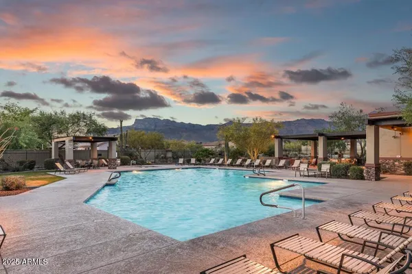 a view of swimming pool with outdoor seating and a garden