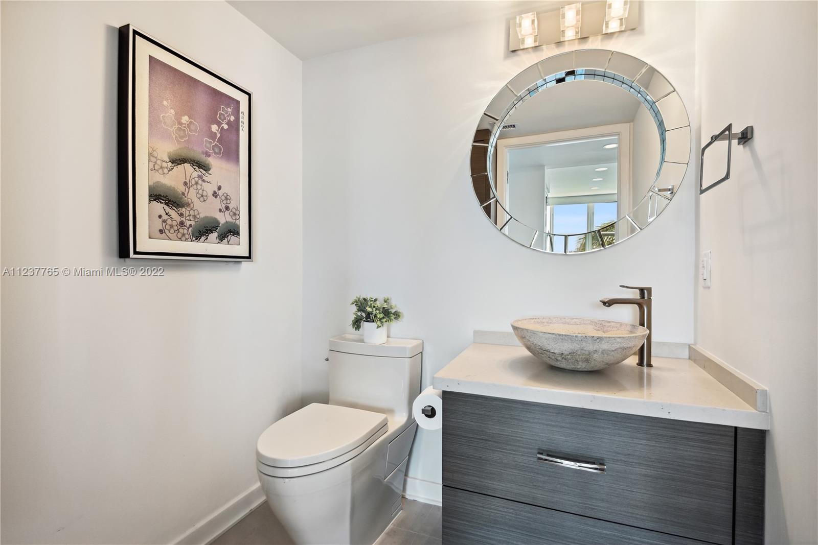 90 Alton Road, Unit TH8 Miami Beach, FL 33139 - Photo 6 of 25 a bathroom with a toilet a sink and mirror