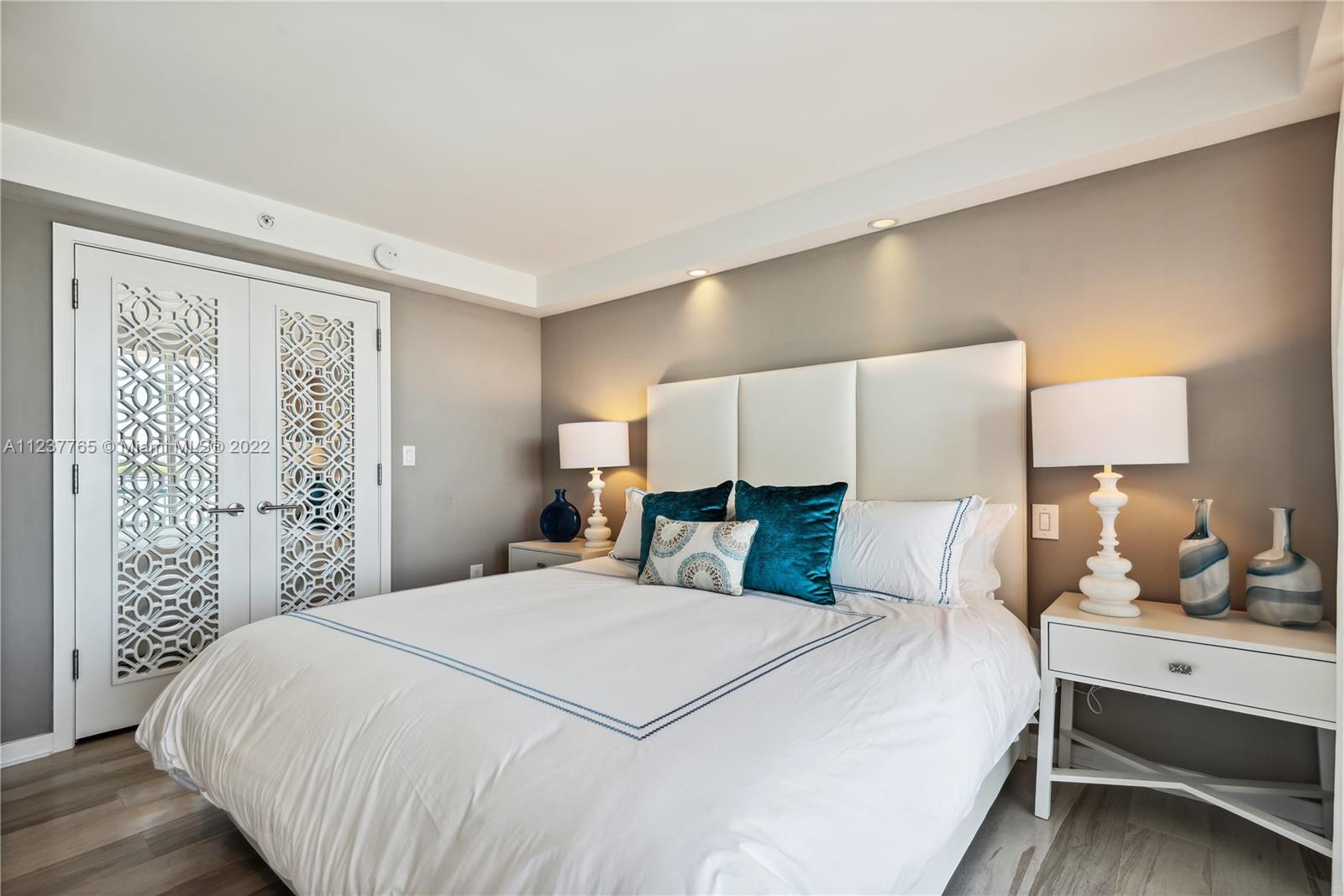 90 Alton Road, Unit TH8 Miami Beach, FL 33139 - Photo 10 of 25 a bedroom with a large bed and lamp