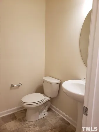 a white toilet sitting next to a white sink and vanity