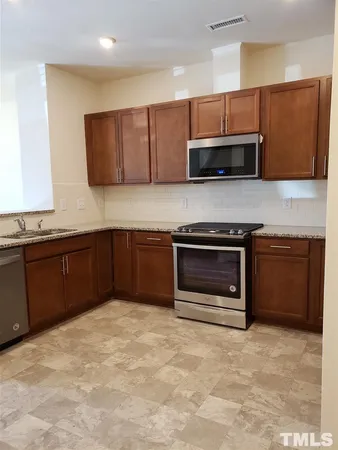 a kitchen with stainless steel appliances granite countertop a stove and a sink