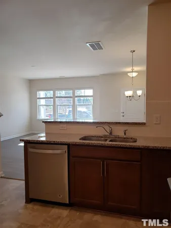 a kitchen with granite countertop a sink and a wooden cabinets