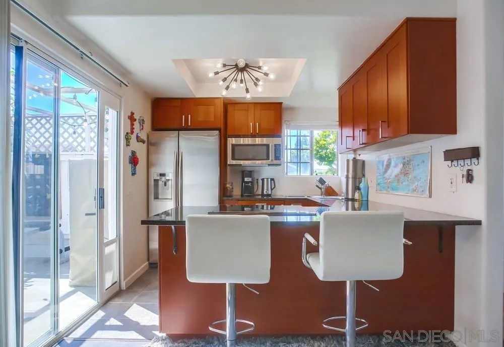 344 Riverview Way Oceanside, CA 92057 - Photo 9 of 41 a kitchen with granite countertop a refrigerator cabinets stainless steel appliances and a dining table