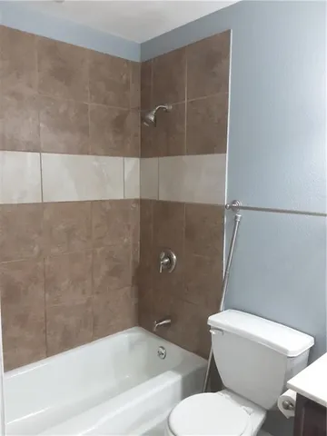 a white toilet and tub sitting next to a bathroom sink