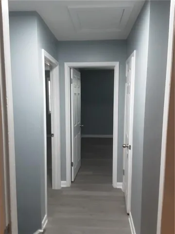 a view of a hallway with wooden shelves