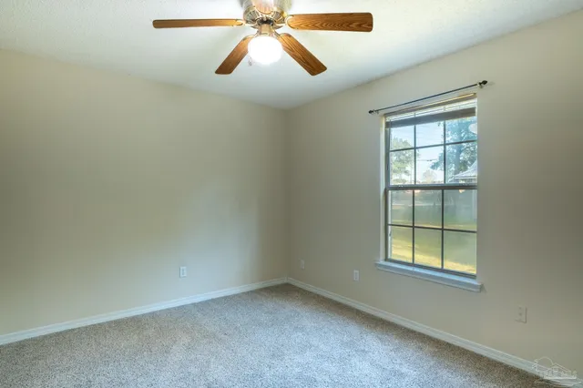 an empty room with a window and a fan