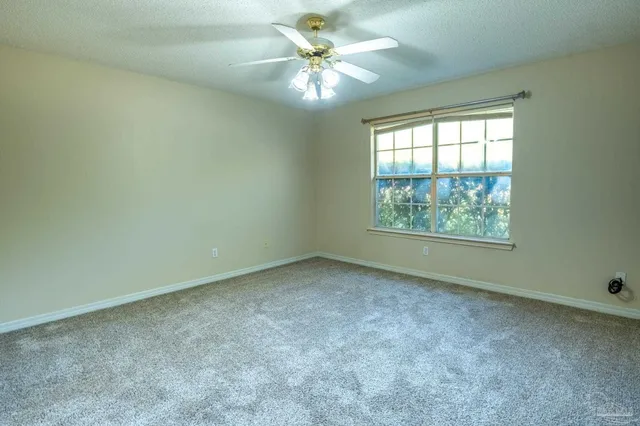an empty room with a window and a fan