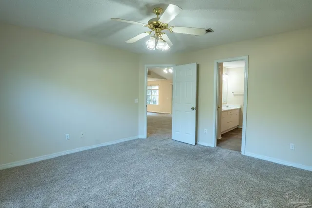 a view of an empty room and a ceiling fan window