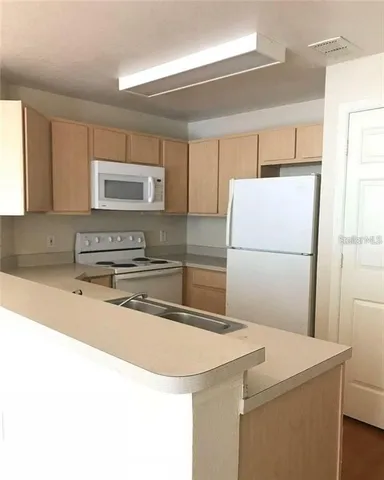 a kitchen with a refrigerator and a sink