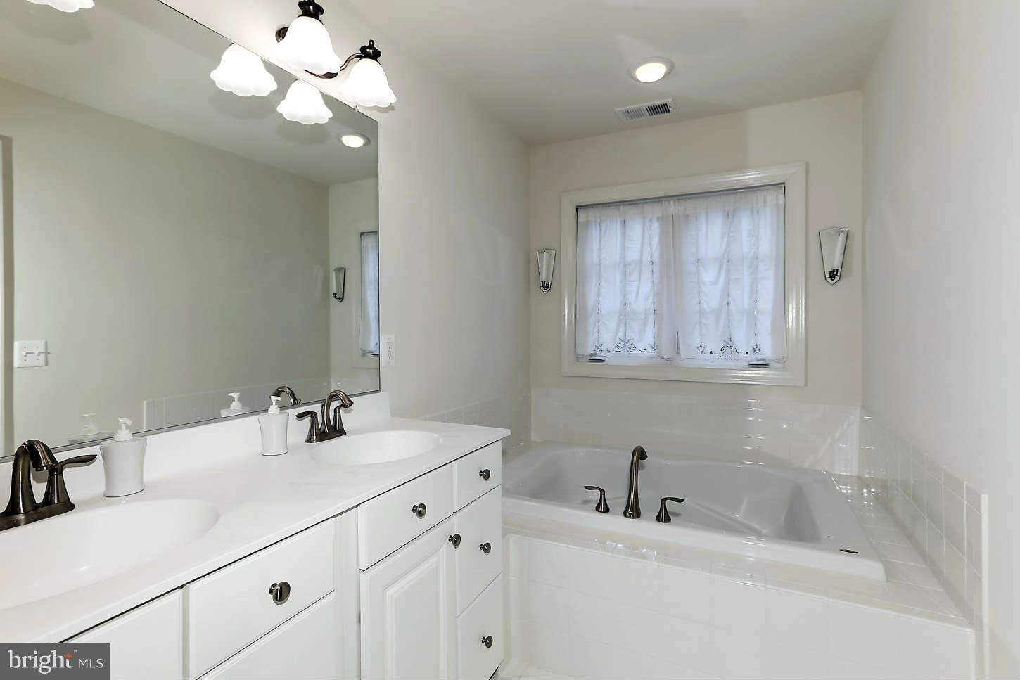 908 West Glebe Road Alexandria, VA 22305 - Photo 19 of 29 a bathroom with a sink a large mirror and a light fixture