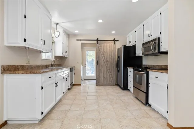 a kitchen with stainless steel appliances a refrigerator sink and cabinets