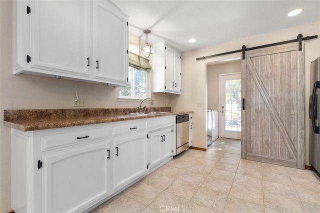 a large white kitchen with white cabinets and a sink