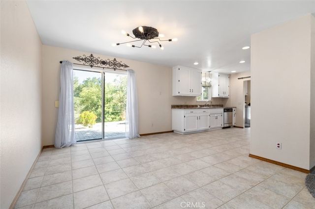 a large kitchen with granite countertop a stove a sink a window and dining table