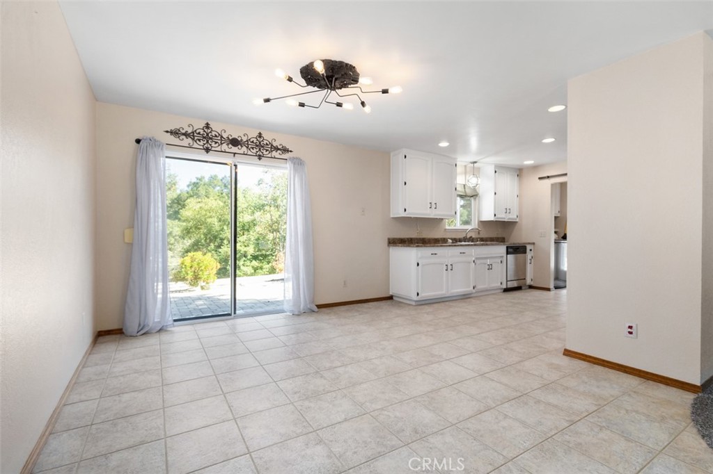 8070 Coromar Avenue Atascadero, CA 93422 - Photo 16 of 49 a large kitchen with granite countertop a stove a sink a window and dining table