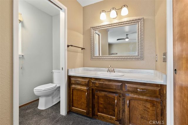 a bathroom with a toilet sink vanity and mirror