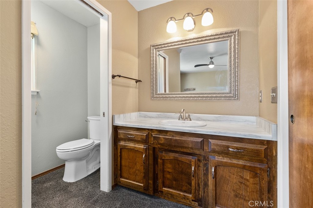 8070 Coromar Avenue Atascadero, CA 93422 - Photo 23 of 49 a bathroom with a toilet sink vanity and mirror