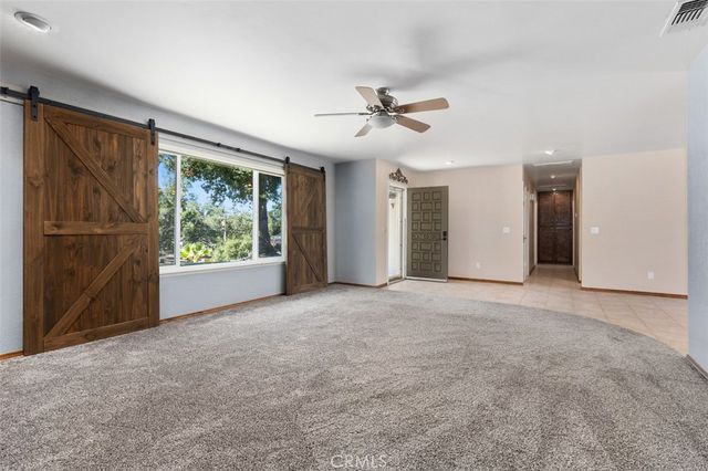 a view of a livingroom with a ceiling fan and window