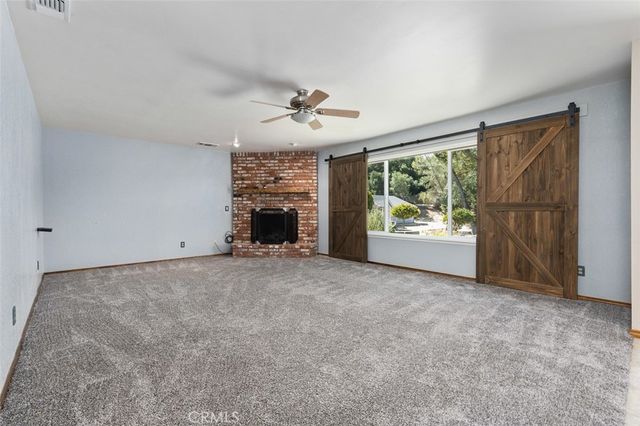 a view of empty room with fireplace and windows