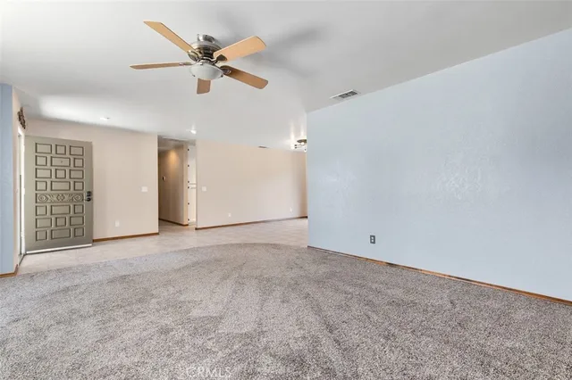 an empty room with closet and ceiling fan
