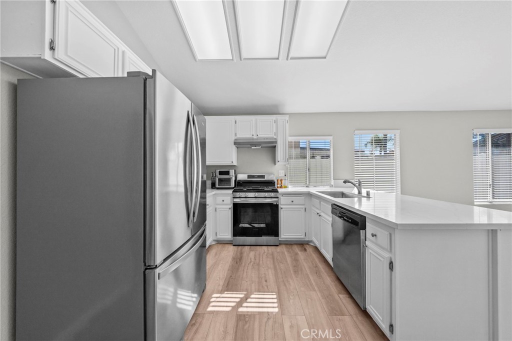 24529 Ridgewood Road Murrieta, CA 92562 - Photo 14 of 43 a kitchen with a refrigerator a sink and a stove top oven