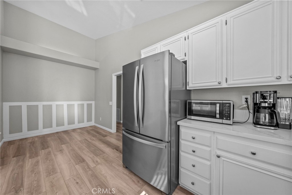 24529 Ridgewood Road Murrieta, CA 92562 - Photo 16 of 43 a kitchen with granite countertop a refrigerator sink and white cabinets