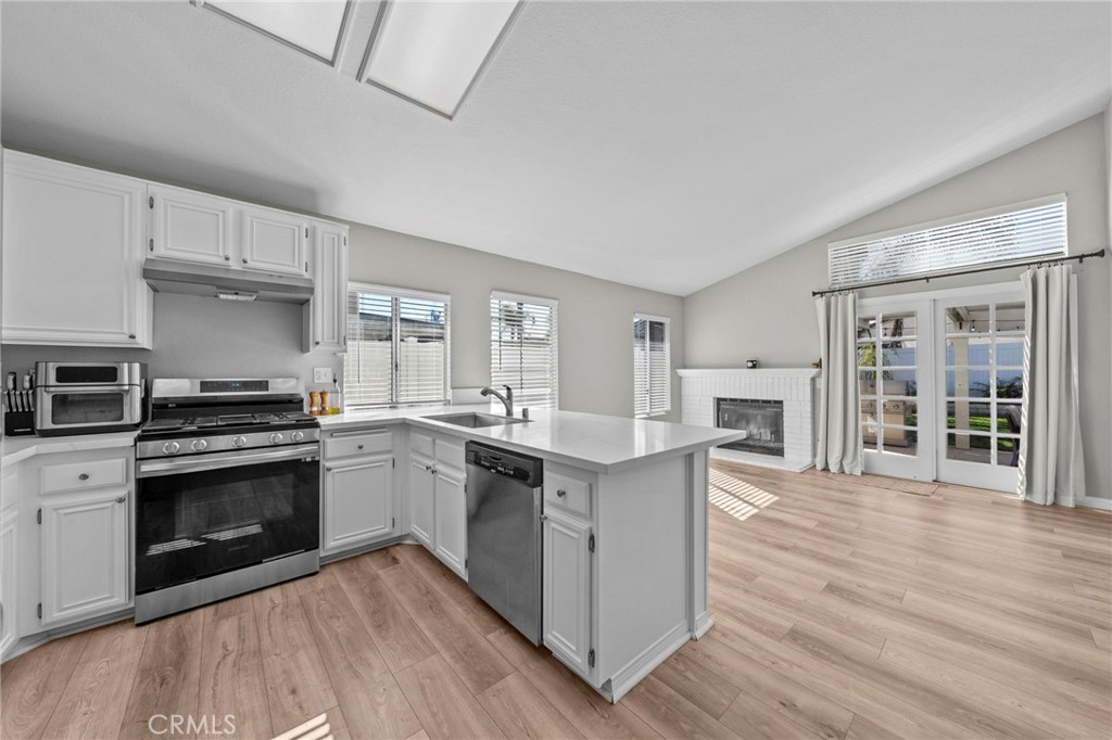 24529 Ridgewood Road Murrieta, CA 92562 - Photo 22 of 43 a kitchen with wooden floors and stainless steel appliances