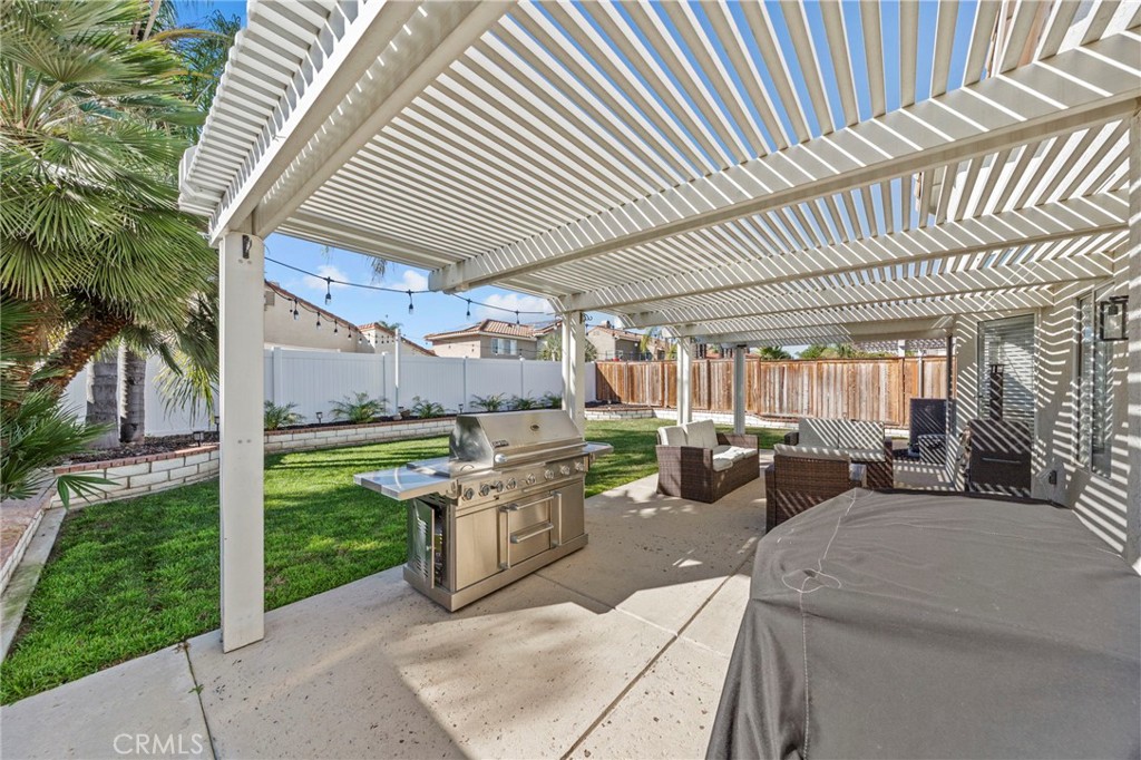 24529 Ridgewood Road Murrieta, CA 92562 - Photo 33 of 43 a view of a patio with table and chairs potted plants and palm trees
