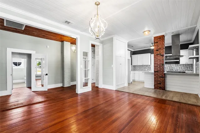 a view of a big room with wooden floor and windows