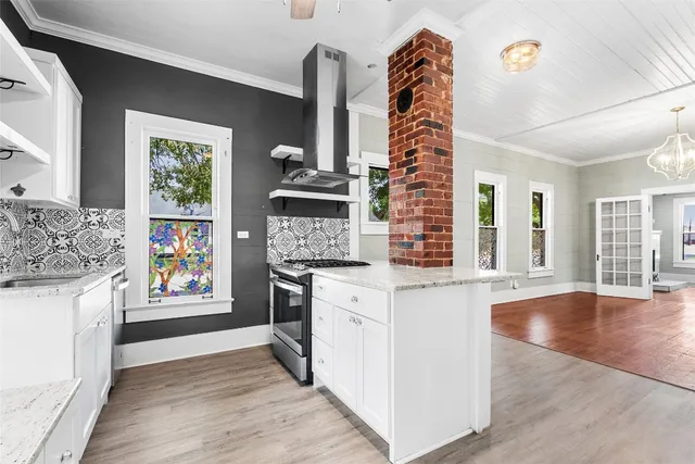 a open kitchen with granite countertop a stove and a wooden floor