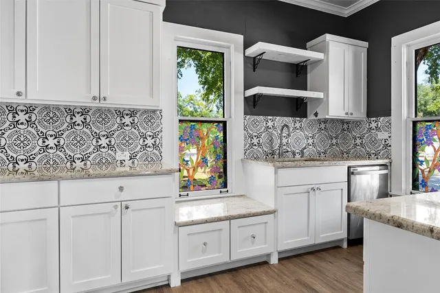a kitchen with granite countertop white cabinets and a sink