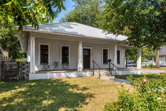 a view of house with a yard outdoor seating and large tree