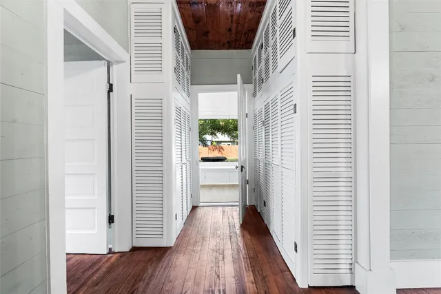 a view of a hallway with wooden floor and staircase
