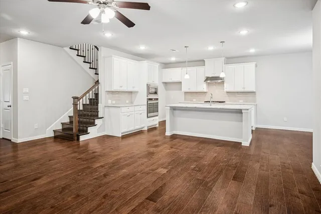 a kitchen with granite countertop white cabinets and white appliances