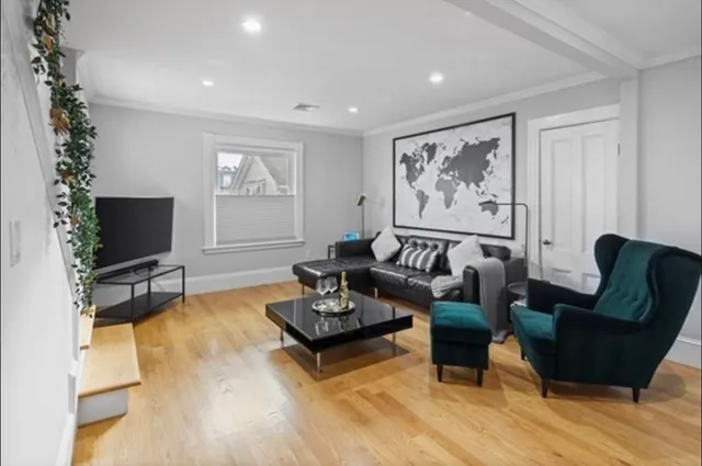 a living room with furniture a flat screen tv and a large window