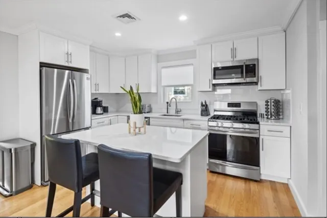 a kitchen with stainless steel appliances a stove a sink refrigerator and a microwave