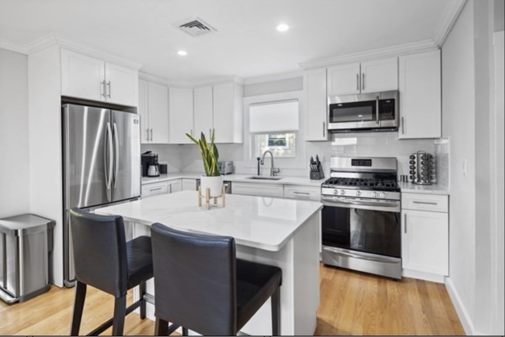 14 Everett Street, Unit 2 Medford, MA 02155 - Photo 10 of 24 a kitchen with stainless steel appliances a stove a sink refrigerator and a microwave