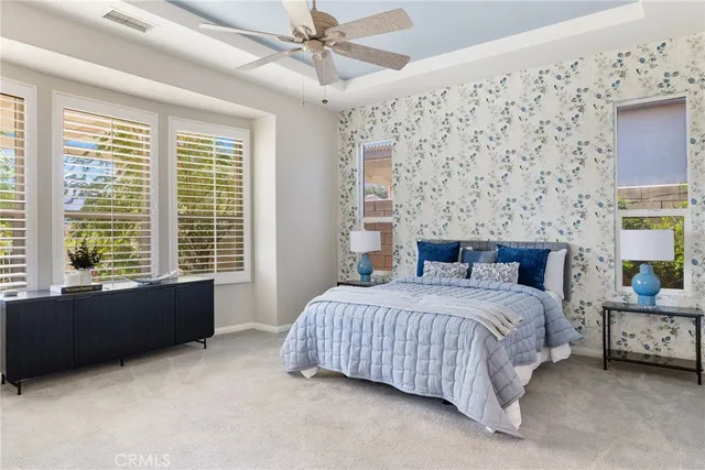 a bedroom with a large bed and a chandelier