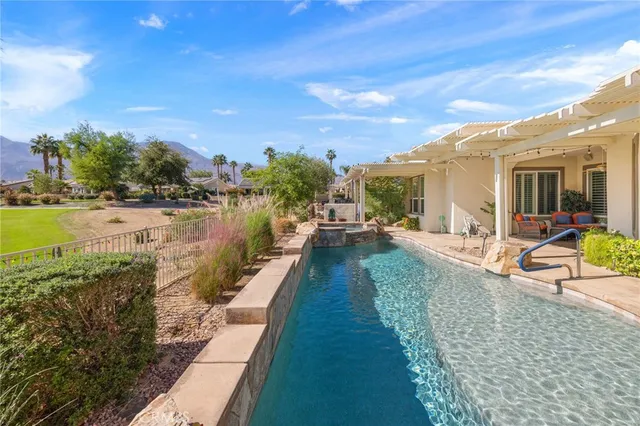 a living room with furniture ceiling fan and a large window