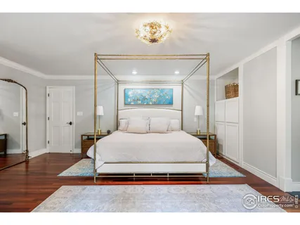 a spacious bedroom with a bed and a wooden floor