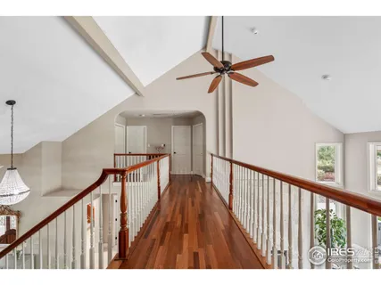 a view of a hallway with wooden floor and stairs