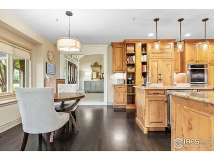 a view of a dining room and livingroom with furniture wooden floor a chandelier