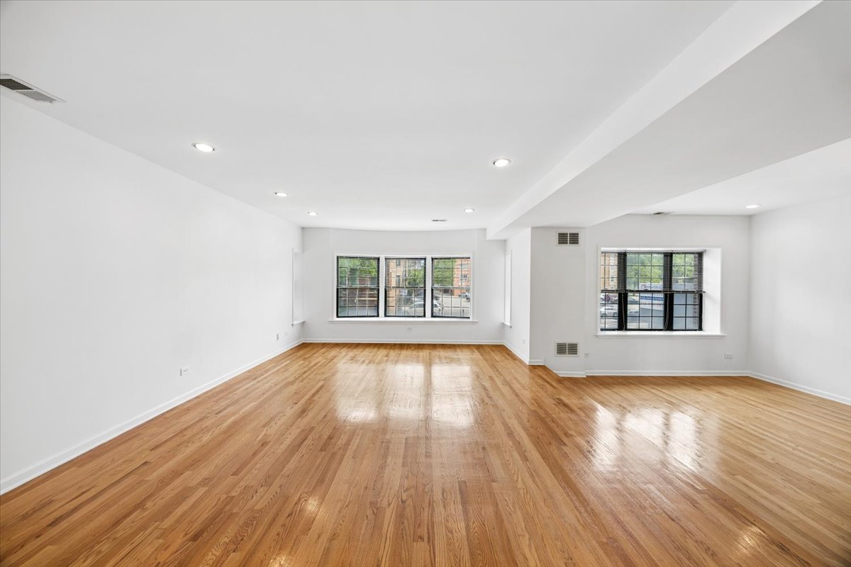 2363 East 70th Street, Unit 1 Chicago, IL 60649 - Photo 5 of 26 a view of empty room with wooden floor and fan